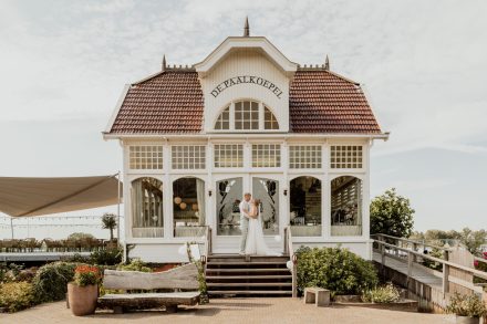 Het bruidspaar neemt een momentje voor zichzelf voor het prachtige gebouw de Paalkoepel in Haren. foto: Wilco de Haan Fotografie, trouwfotograaf Winschoten, Groningen