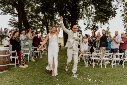 Floortje en Edwin lopen de trouwceremonie uit bij boerderijcafé Mausel als getrouwd stel! foto: Wilco de Haan Fotografie, trouwfotograaf Winschoten, Groningen