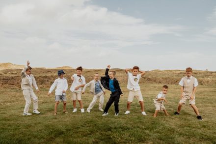 De kinderen doen een dansje in de duinen van Texel. foto: Wilco de Haan Fotografie, trouwfotograaf Winschoten, Groningen